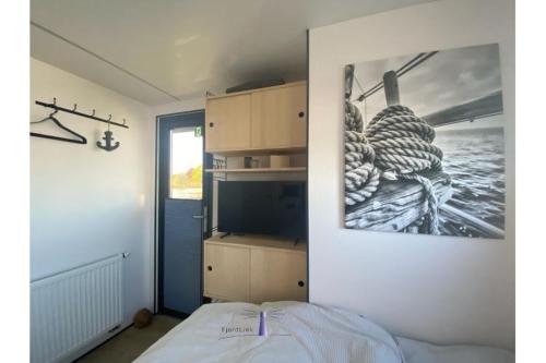 1 dormitorio con 1 cama y una foto en la pared en Hausboot Fjord Ankerplatz mit Biosauna in Schleswig, en Schleswig