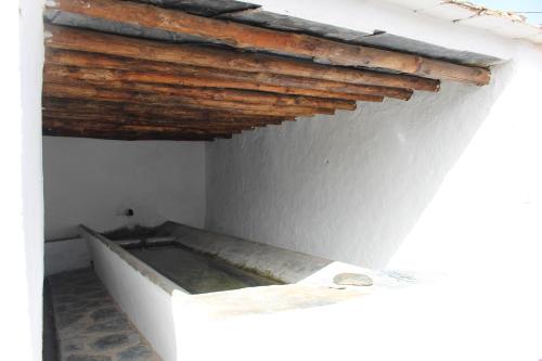 a bathtub in a room with a wooden ceiling at Casa Estrella de las nieves La Alpujarra in Bérchules
