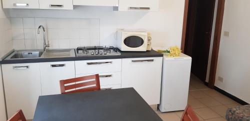 a small kitchen with a sink and a microwave at Coccodrillo Hotel & Apartments in Varazze