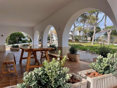 patio con tavolo in legno e alcune piante di BINIFORCAT a Cala'n Forcat