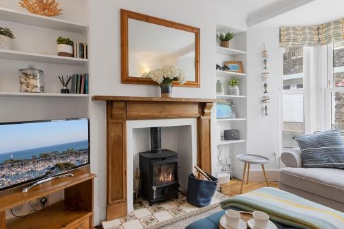 a living room with a fireplace and a tv at Polly's Place, Brixham in Brixham