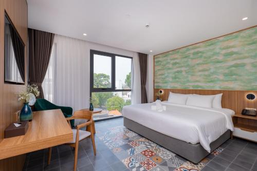 een hotelkamer met een groot bed en een bureau bij Petro House Vung Tau in Vung Tau