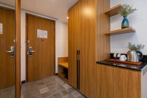 a kitchen with wooden cabinets and a door at Petro House Vung Tau - Block A in Vung Tau