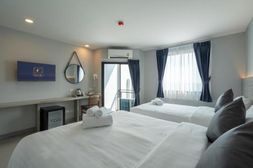 a hotel room with two beds and a fireplace at Cozy Blu Suvarnabhumi in Samutprakarn