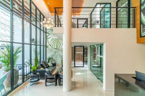 an open lobby with glass walls and plants at Amber Boutique Silom in Bangkok