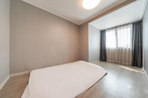 a bedroom with a large bed and a window at Gyeongpo Soo Hotel in Gangneung