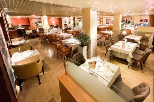 アウクスブルクにあるシティ ホテル オスト アム ケーのテーブルと椅子のあるレストラン、ダイニングルーム