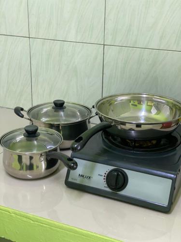 a stove with two pots and pans on it at AISY HOMESTAY - Rumah 4,5 in Kampong Tanjong Karang