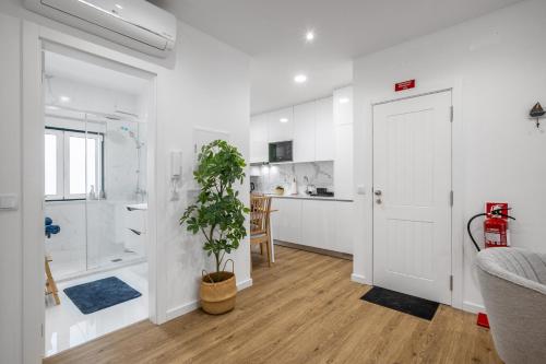 baño blanco con ducha y planta en Sueños Del Mar, en Nazaré