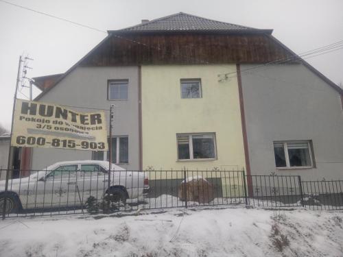 ein Gebäude mit einem Auto im Schnee in der Unterkunft Hunter 3 in Jugów