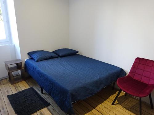um quarto com uma cama azul e uma cadeira vermelha em Gîte des Pleiades em Villemoirieu