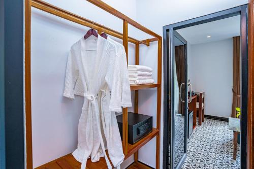a robe hanging on a rack in a bathroom at Kampot Sweet Boutique in Kampot