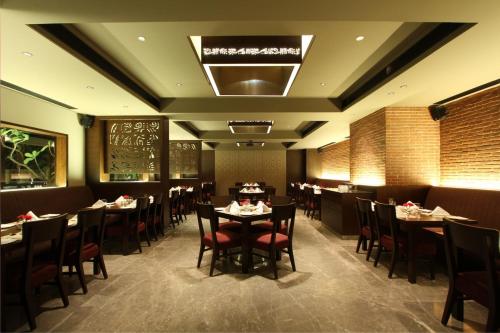 a dining room with tables and chairs in a restaurant at Hotel Express Residency Vadodara in Vadodara