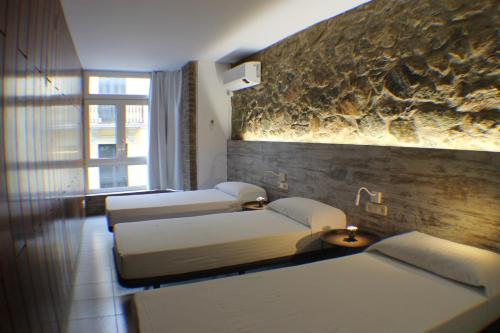 uma fila de camas num quarto com uma janela em Agi Pi Sunyer Apartments em Roses