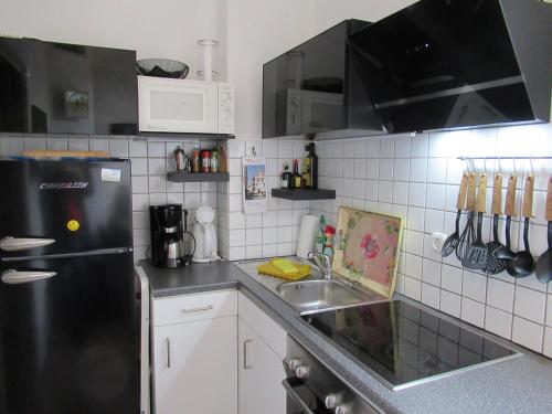 een keuken met een zwarte koelkast en een wastafel bij Ferienwohnung An der Itz in Coburg
