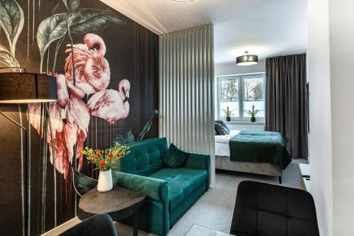 uma sala de estar com um sofá verde e um quarto em K20 Apartamenty Łódź - Dostęp na Kod em Lódź