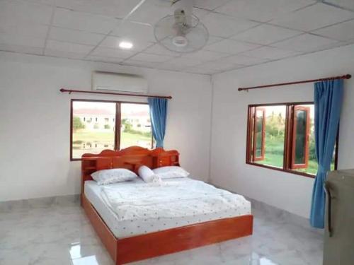 a bedroom with a large bed with blue curtains at Ban Saylomleng Residence in Vientiane