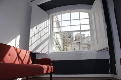 a living room filled with furniture and a window at Largo da Sé Guest House - HOrigem in Lisbon
