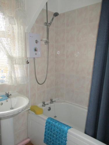 a bathroom with a shower and a tub and a sink at SUPER SINGLE ROOM in Cardiff