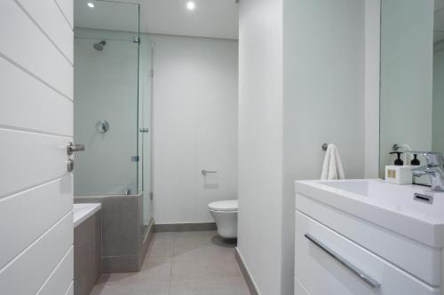 a bathroom with a sink and a toilet and a shower at Modern Garden Unit in Pebble Beach in Umhlanga
