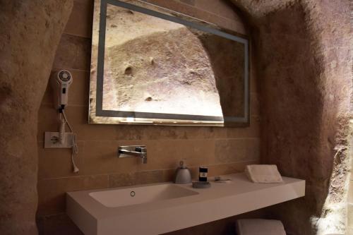 a bathroom with a sink and a mirror at 5 Elementi Sassi Matera in Matera