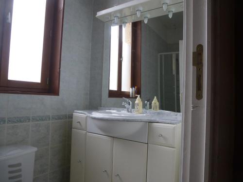 a bathroom with a white sink and a mirror at L'Horizon des Alpes in Le Petit-Bornand-lès-Glières