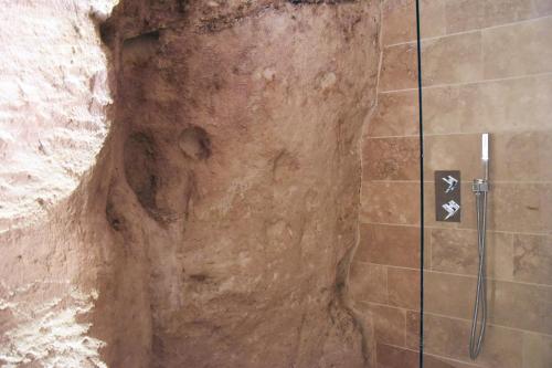 a bathroom with a shower in a cave at 5 Elementi Sassi Matera in Matera