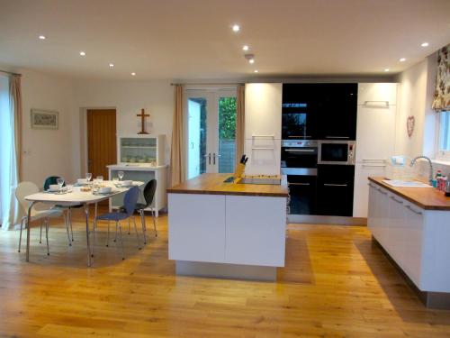 a kitchen and dining room with a table and a kitchen and a dining room at Acorn Chapel - Beautiful Converted Chapel in Norwich