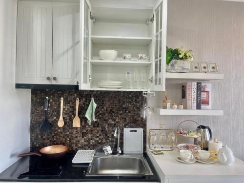 a kitchen with white cabinets and a sink at Love on top @ The Blu X bangsaen in Ban Bang Saen (1)