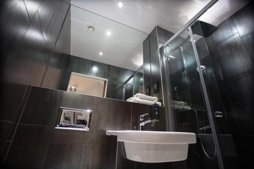a bathroom with a sink, toilet and bathtub at The W14 Hotel in London