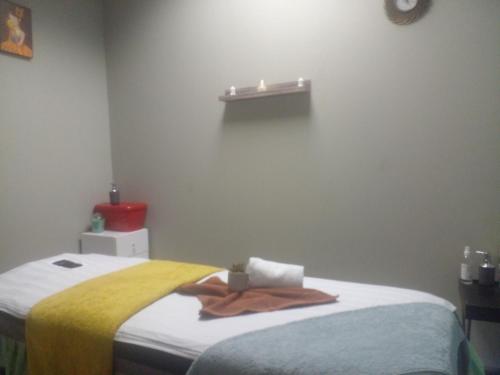 una camera da letto con un letto e un asciugamano sopra di DeeCinta Health Spa a Johannesburg