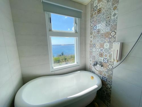 a white bath tub in a bathroom with a window at 南鴻雅築South Home in Nanwan