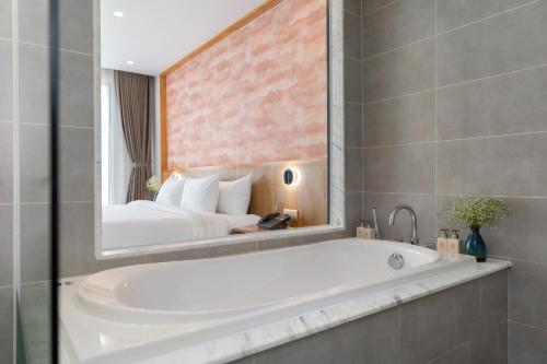 a bathroom with a bath tub and a bedroom at Petro House Vung Tau in Vung Tau