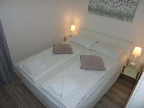 a white bed in a room with two lamps at APARTMENT KAYA in Zadar