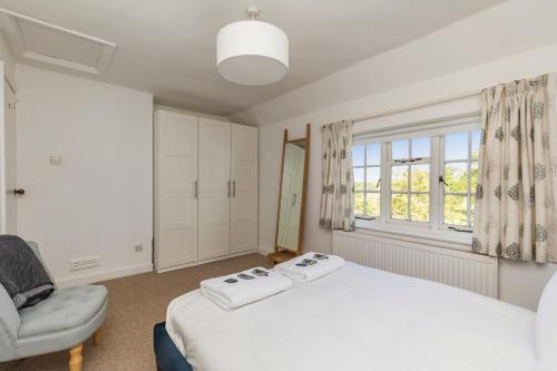 a bedroom with a bed and a chair and a window at Danny Lodge - Country Cottage Near Brighton by Huluki Sussex Stays in Hurstpierpoint