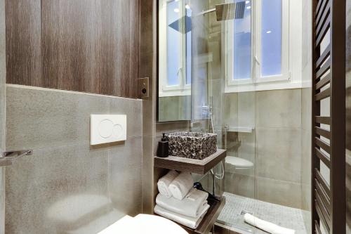 ein Bad mit einem Waschbecken, einem WC und einem Fenster in der Unterkunft Pick A Flat's Apartment in Triangle d'Or - Pierre 1er de Serbie in Paris
