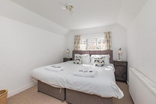 um quarto com uma grande cama branca e 2 almofadas em Danny Lodge - Country Cottage Near Brighton by Huluki Sussex Stays em Hurstpierpoint