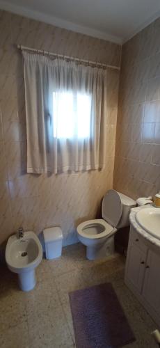 a bathroom with a toilet and a sink and a toilet istg at Gira-sol villa in Vidreres