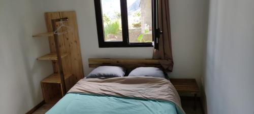 a small bedroom with a bed and a window at La maison Loé in Cilaos