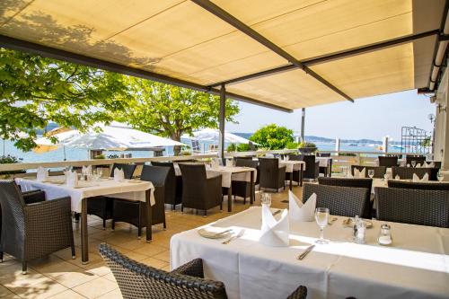 a restaurant with tables and chairs with a view of the ocean at Seehotel Leoni in Berg am Starnberger See