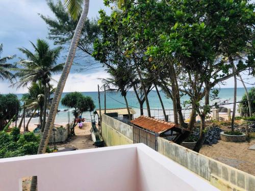 uitzicht op het strand vanaf het balkon van een resort bij Hotel Meer in Ambalangoda