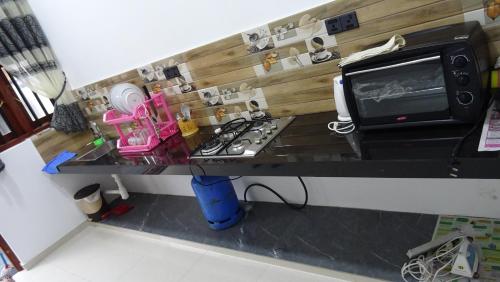 een keuken met een aanrecht met een fornuis en een magnetron bij Hotel Meer in Ambalangoda
