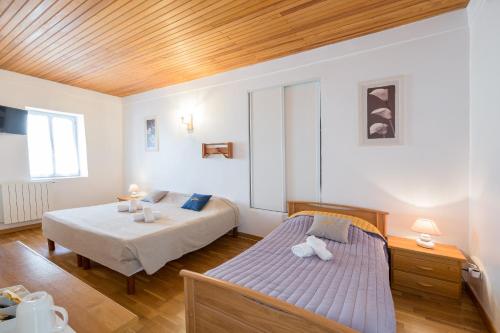 1 dormitorio con 2 camas y techo de madera en San Larenzu, en Aullène