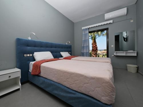 a bedroom with a large blue bed with a blue headboard at Hotel Marvel in Arillas
