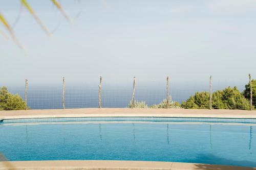 a blue swimming pool with the ocean in the background at Casa Tramuntana in Valldemossa