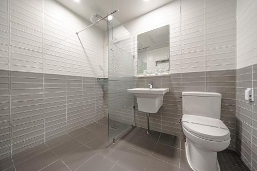 a white bathroom with a toilet and a sink at Gyeongpo Soo Hotel in Gangneung