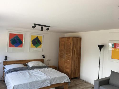 ein Schlafzimmer mit einem Bett und einem Stuhl in der Unterkunft Gästehaus - Kunststiftung Bernhard Müller-Feyen in Adenau