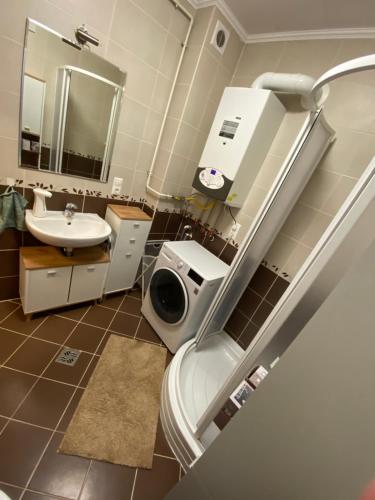 a bathroom with a sink and a toilet and a mirror at PannaRoza Apartman in Balatonlelle