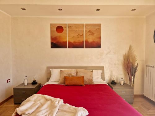 um quarto com uma cama vermelha com duas mesas de cabeceira em TraMonti Apartments em Poggio Picenze