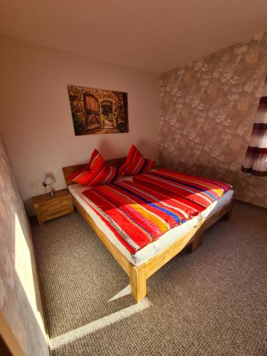 a bedroom with a large bed with red pillows at Ferienwohnung Weber in Neustadt in Sachsen